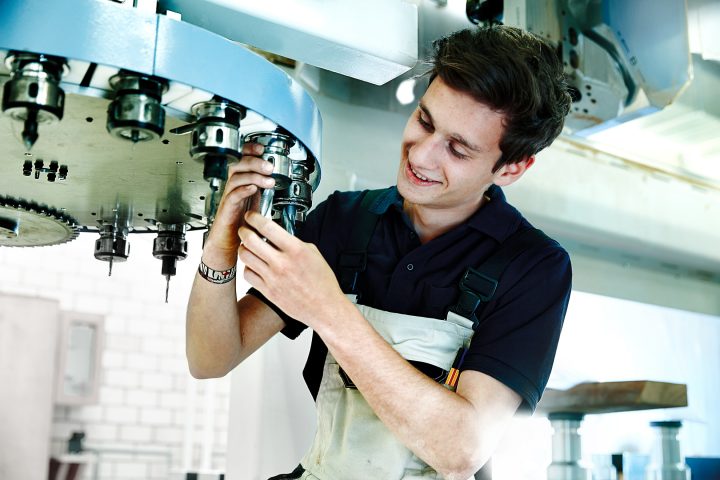 Arbeiter repariert industrielle Maschine in Fabrik.