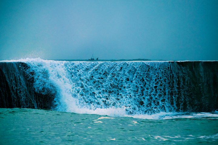 Blaue Wasserfall, mit Boot im Hintergrund sichtbar.