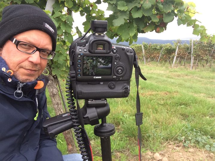 Fotograf mit Kamera in einem Weinberg