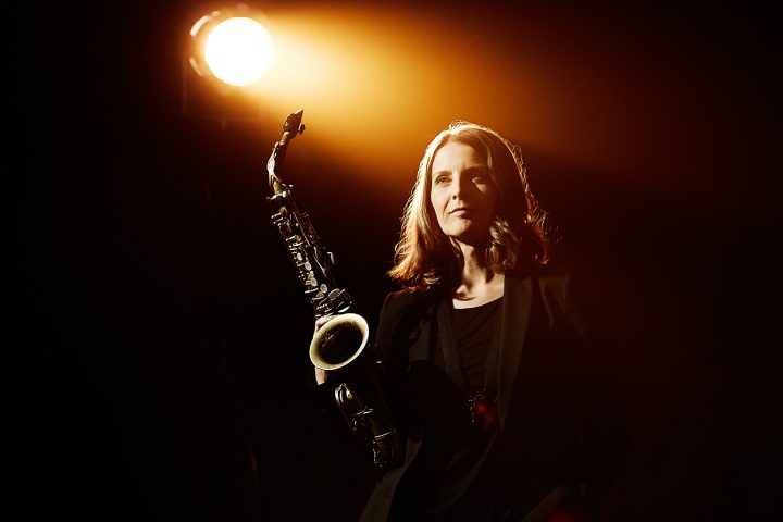 Frau spielt Saxophon im Scheinwerferlicht