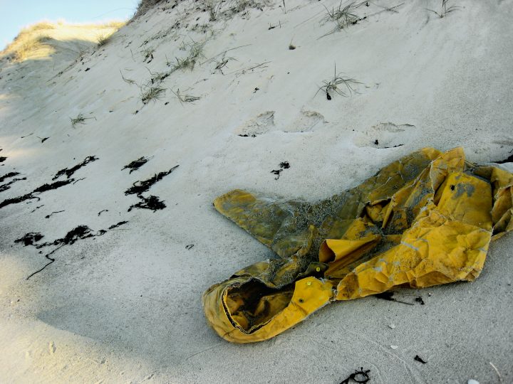 Gelbe Jacke im Sand am Strand.