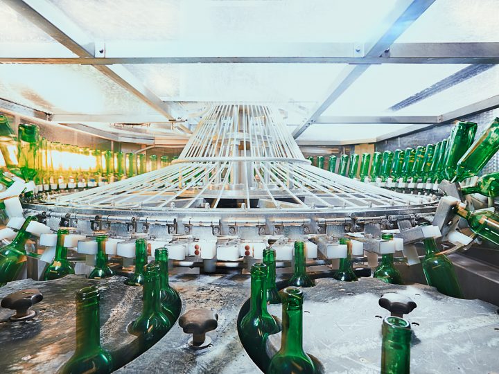 Grüne Flaschen auf Förderband in Abfüllanlage