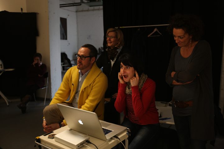 Gruppe von Menschen beim Betrachten eines Bildschirms im Studio.