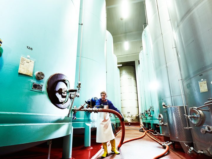 Mann in der Brauerei neben großen Tanks
