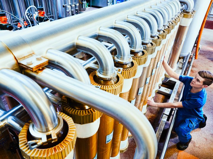Techniker arbeitet an industrieller Rohrleitungsanlage