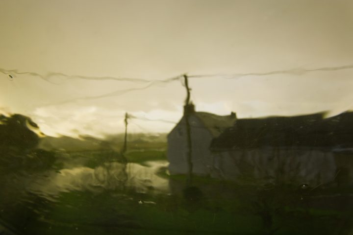 Verschwommene Landschaft mit Haus im Regen