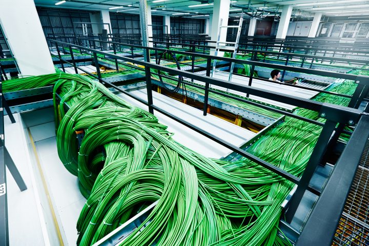 Grüne Kabel in einem modernen Serverraum verteilt.