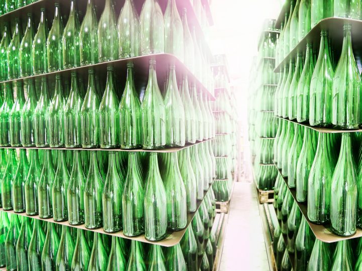 Viele grüne Glasflaschen in Regalen.