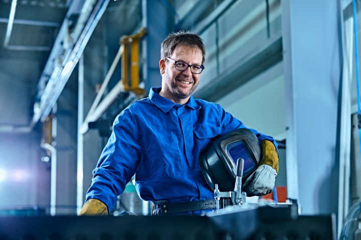 Industriemechaniker mit Sicherheitsausrüstung in Fabrikhalle
