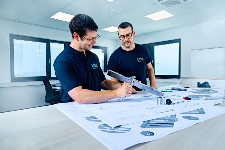 Ingenieure arbeiten an technischen Zeichnungen im Büro.