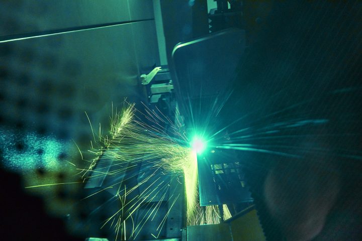 Laser schneidet Metall mit Funken in Fabrik