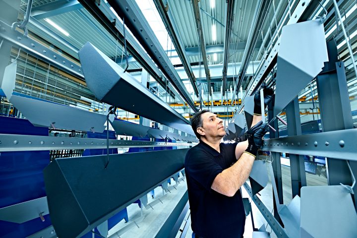 Mann arbeitet in einer Metallfabrik an Stahlstrukturen.