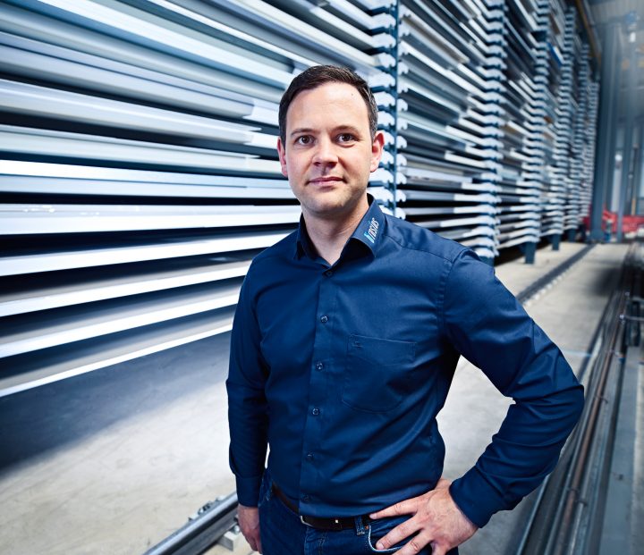 Mann in Lagerhalle mit Regalen