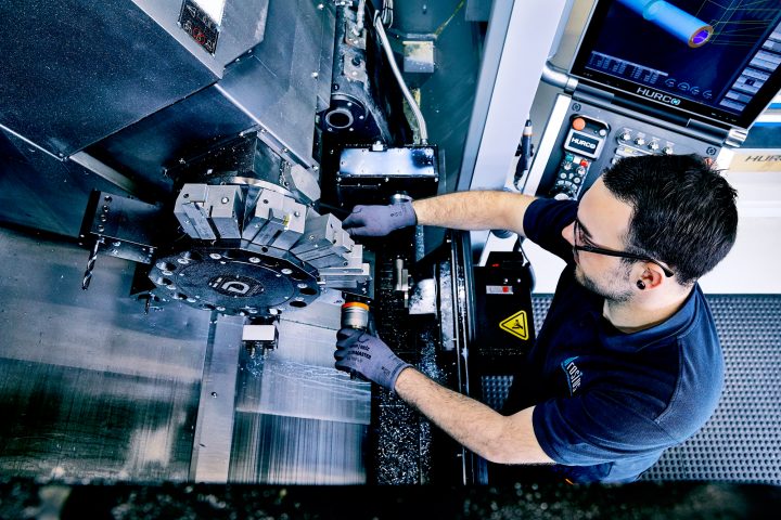 Techniker bedient CNC-Maschine in Werkstatt