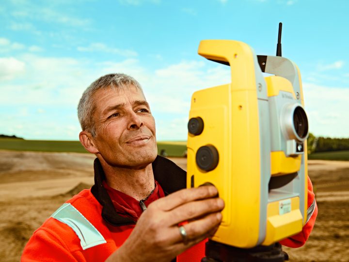 Vermessungstechniker bei der Arbeit mit Totalstation