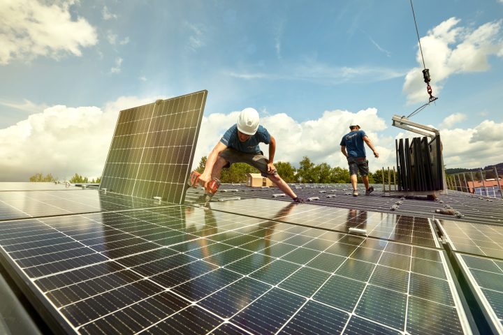 Arbeiter installieren Solarmodule auf einem Dach