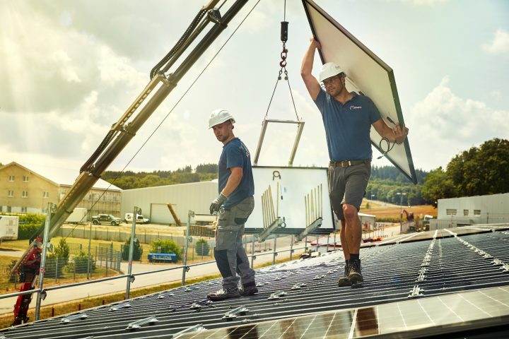 Arbeiter installieren Solarpanels auf einem Dach